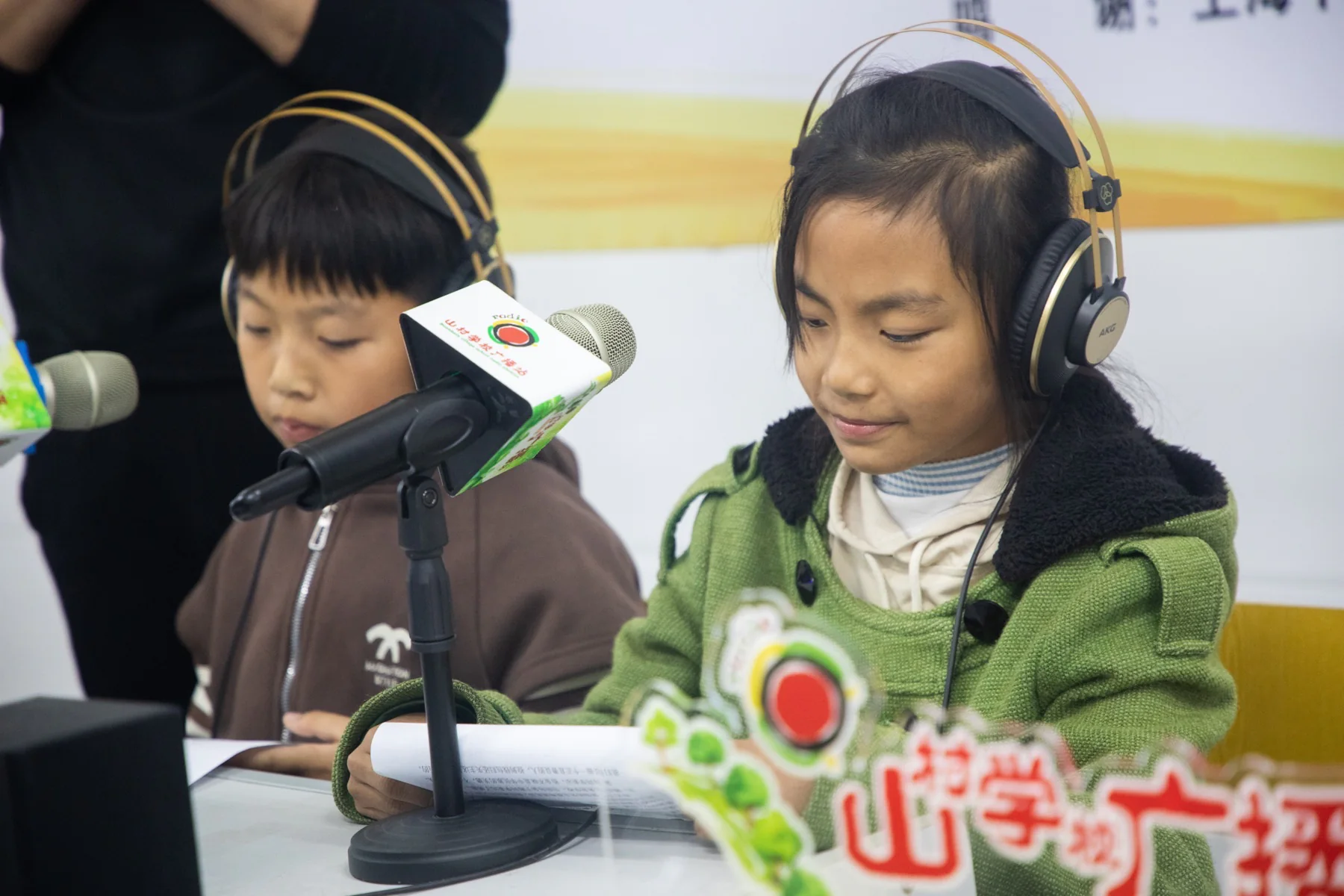 孩子在校园广播话筒前练习播音