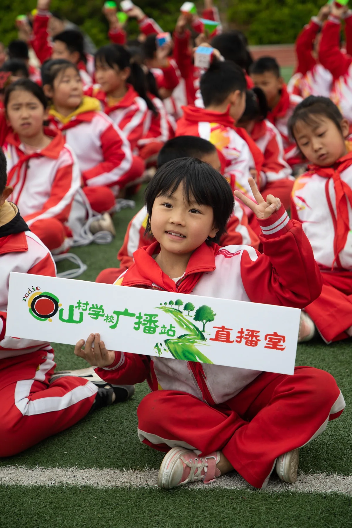 孩子在校园活动中展示广播站标识